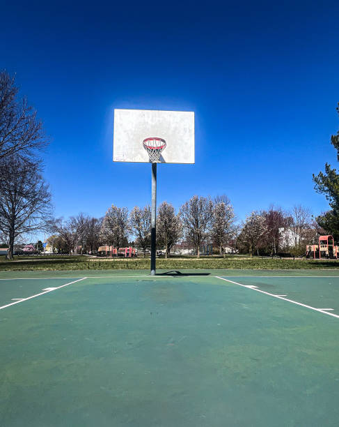 Two young African American men playing street basketball.  