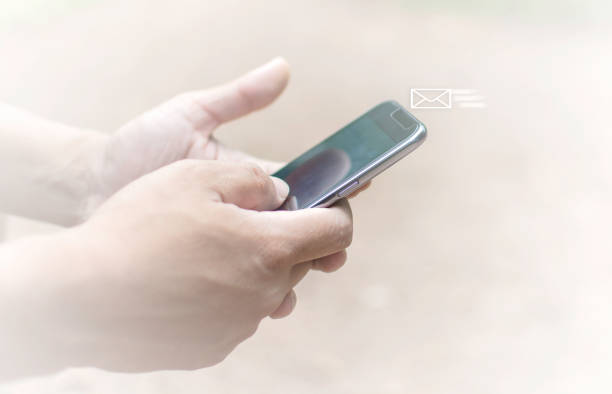 letter fly in the mobile phone, man hold mobile phone with email received on white background tone