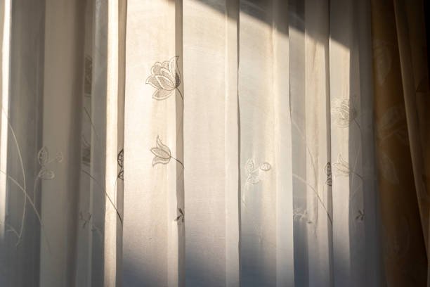 istock White lace curtains blocking the sunlight coming through the window 2196491887