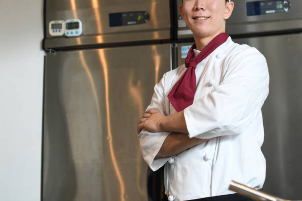 istock Smiling male chef with arms crossed looking at camera in the kitchen 2196494210