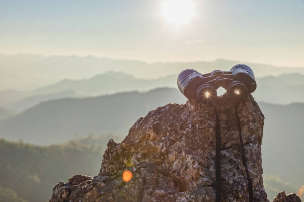 istock binoculars on top of rock mountain at sunset 2196495918