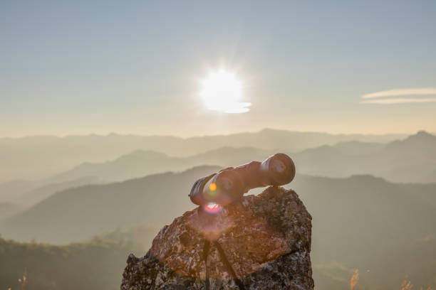 istock binoculars on top of rock mountain at sunset 2196495923