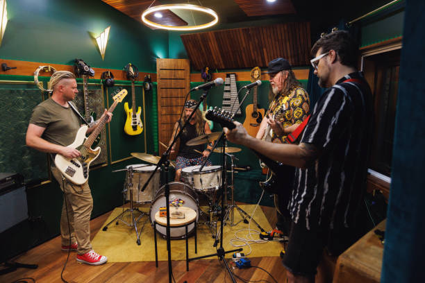 istock Bandmates getting the band back together and playing and singing in rehearsal space 2196496193