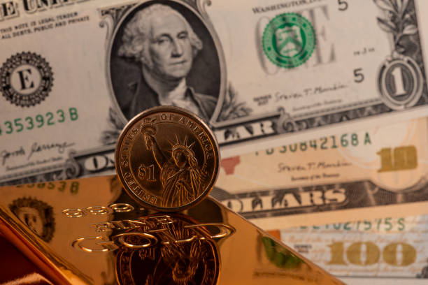 istock 999 gold bar and $1 coin 2196497538