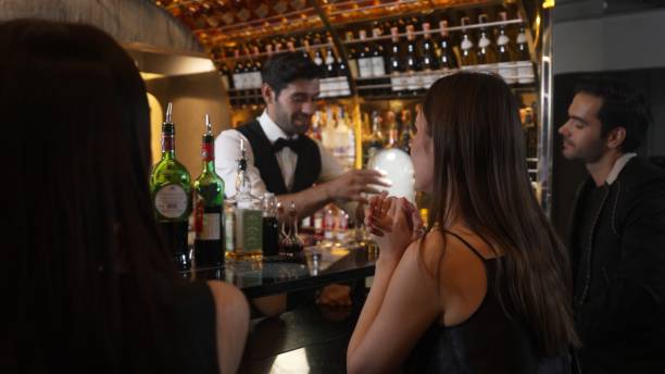 istock Serving drink to customer with couple in mist cocktail by bartender. Vinosity. 2196498019