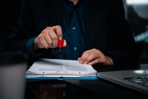istock Business holding rubber stamp document approval verification. Corporate executive legal papers with official stamp document authentication. Notary service provider certify important business contract 2196499349