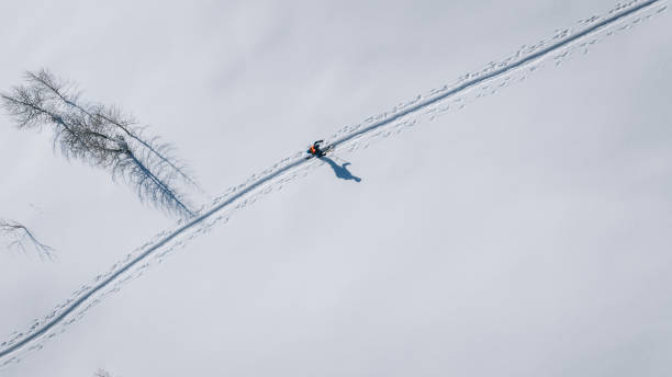 Bird's-eye view of backcountry splitboarder climbing mountain