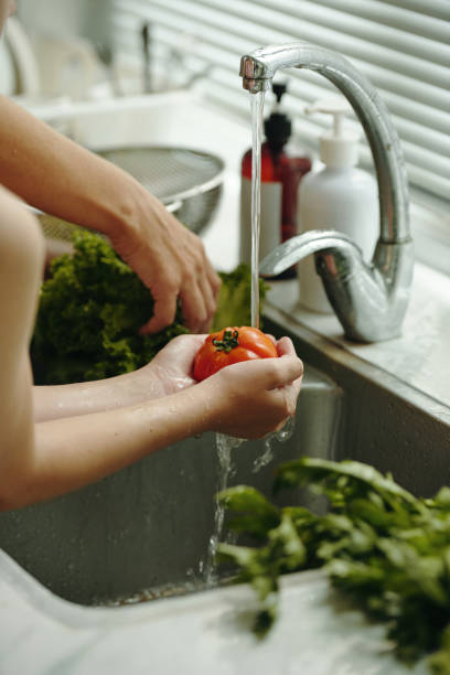 istock Girl Helping Her Mom To Wash Vegetables 2196504302