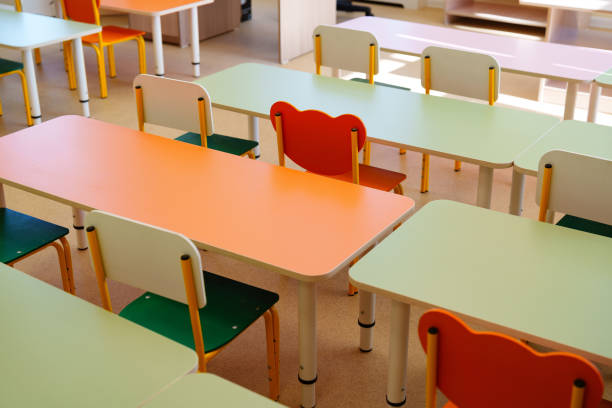 istock Brightly colored classroom furniture arranged in a learning space with empty desks and chairs during school hours 2196505772