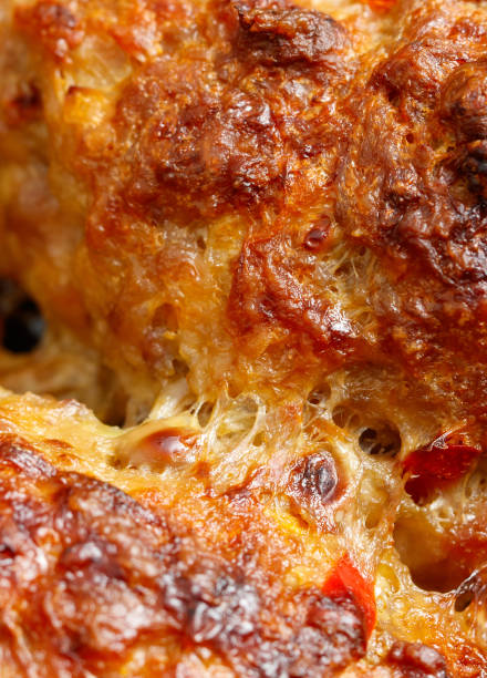 A slice of pizza with melted cheese and pepperoni. The crust is slightly burnt and the cheese is bubbly