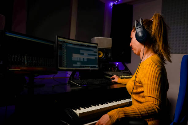 istock Music producer working in professional recording studio using computer and keyboard 2196506203