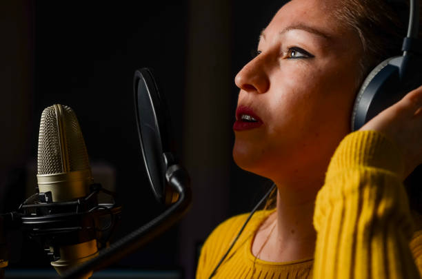 istock Singer recording song with microphone in recording studio 2196506225