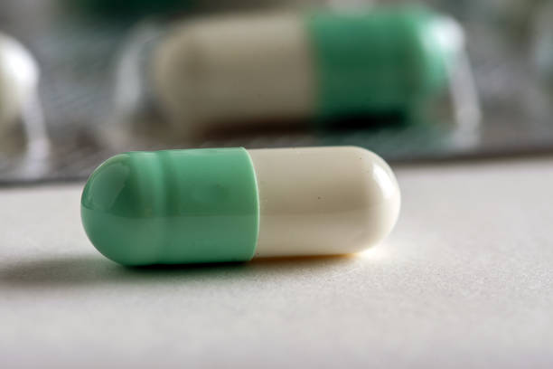 istock Close-Up of Green and White Capsule on White Surface 2196506381
