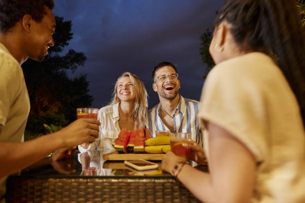 istock Happy friends talking during social gathering at night. 2196507769