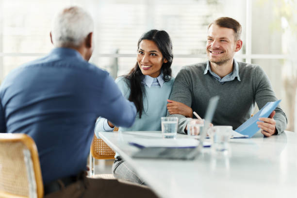 istock Happy diverse couple shaking hands with insurance agent in the office. 2196508558