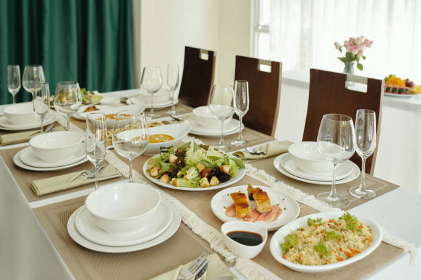 Dining table with plates and wine glasses serving with delicious meal in the restaurant