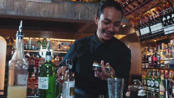 istock Asian bartender pouring mixed juice cocktail ingredients into shaker. Vinosity. 2196510270