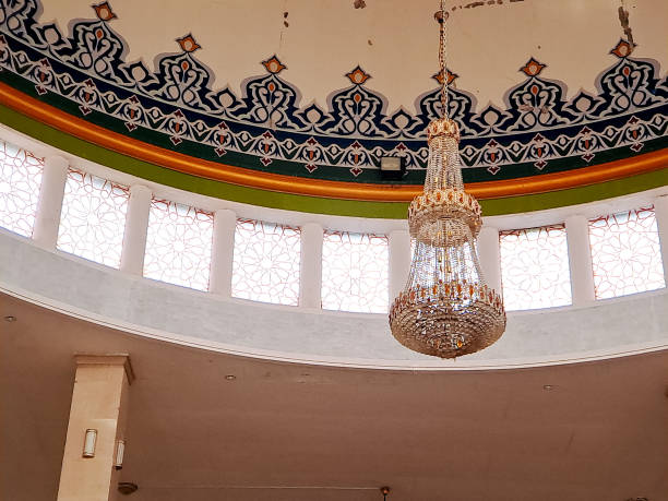 istock crystal chandelier hangs elegantly beneath a painted dome ceiling with intricate Islamic motifs, creating a sense of awe and spirituality within a mosque 2196515737