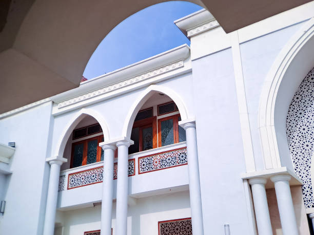 istock framed view of a white mosque facade with arched windows and balconies, set against a vibrant blue sky 2196515859