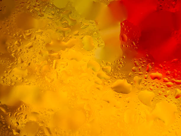 istock Abstract background with water droplets on a surface, creating a vibrant interplay of yellow and red colors 2196516464