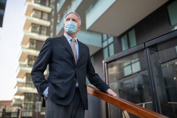 istock Confident businessman wearing protective face mask looking up at the sky 2196518016