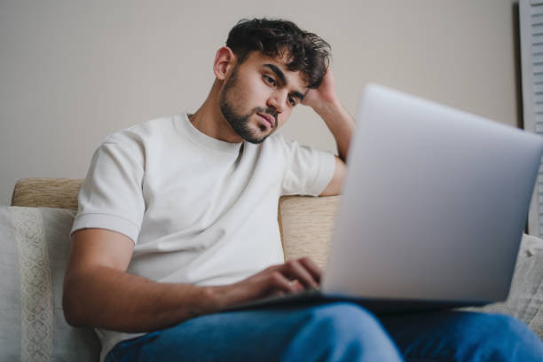 istock A Young Man Working on His Laptop While Relaxing Comfortably at Home in a Cozy Environment 2196518149
