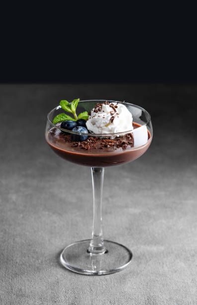 istock Chocolate pudding in a glass with whipped cream, fresh blueberries and mint on a dark background. 2196519524