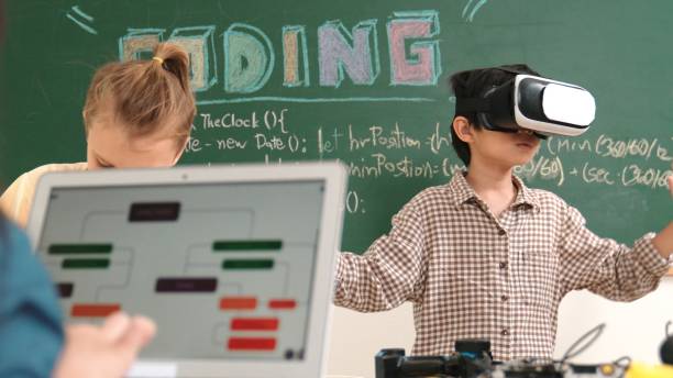 istock Boy wearing VR headset to enter metaworld while girl coding system. Pedagogy. 2196520566