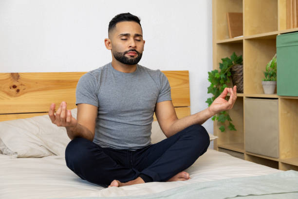istock Young adult meditating on bed for relaxation 2196521275