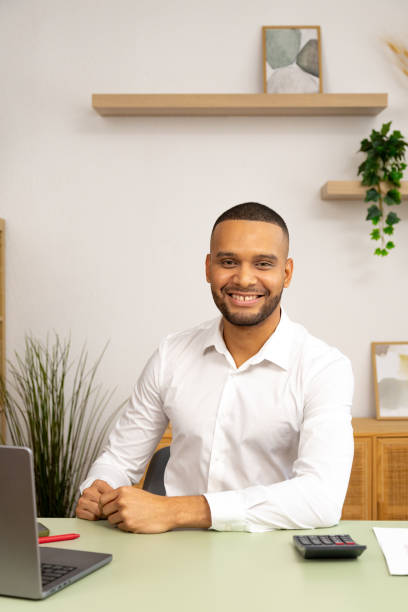 istock Young businessman smiling at the camera in his modern office 2196521354