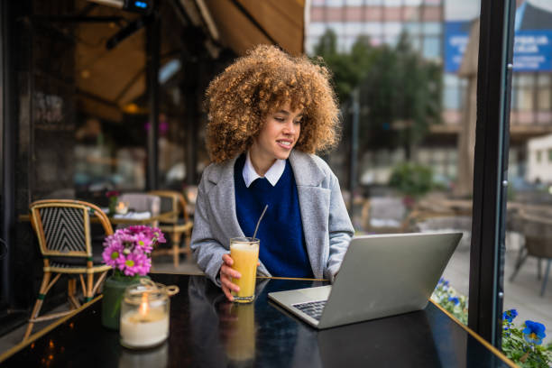 istock Young freelancer working on laptop at outdoor cafe 2196522458