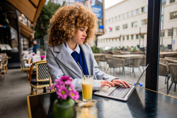 istock Young freelancer working on laptop at outdoor cafe 2196522496