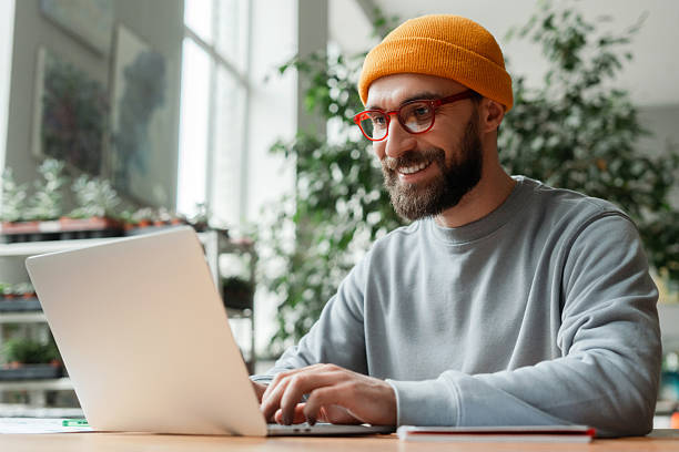 istock Young Adult Man Working on Laptop in Bright Office 2196522699
