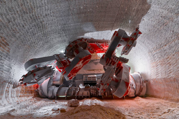 Mining machine cuts layers of mineral ore with saw in deep quarry tunnel. Contemporary machinery for sources extraction. Underground works