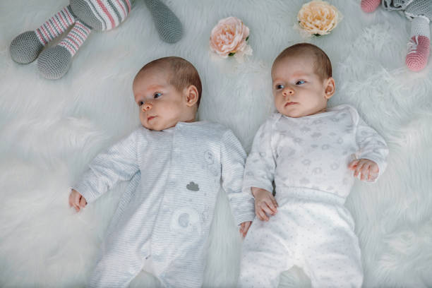 istock Twin Baby Girls Holding Hands on a Soft Blanket 2196523964