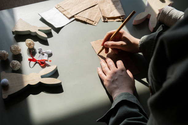 istock Step by step instruction of making handmade Easter gift bag rabbit bunny shaped sustainable materials decorations from craft paper. Female hands creating craft homemade present. Easter celebration ideas 2196525465