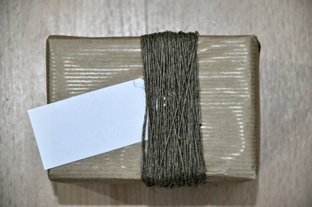 Gift packaging made of gray paper and jute string, with a white tag christmas gift