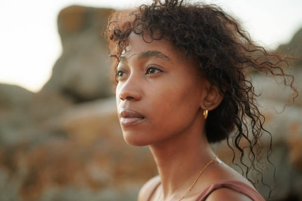 istock Young black woman with windswept hair posing outdoors under natural light 2196529172