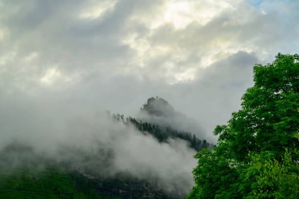 Cloudy mountin view in the village Caprile in the Dolomites surrounded by clouds during sunset after a beautiful springtime day. The Civetta is a prominent and major mountain of the Dolomites, and is popular amongst mountaneers to climb as its one of the highest rock formations in Europe.