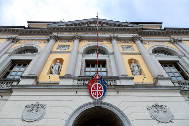 Lugano, Switzerland - Dec 22, 2024: Neoclassical facade of Lugano City Hall with statues and the city emblem