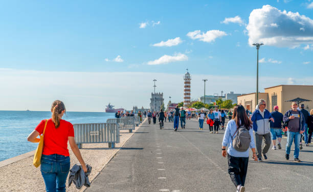 Lisbon, Portugal - October 30, 2024: Tourists walking by the sea