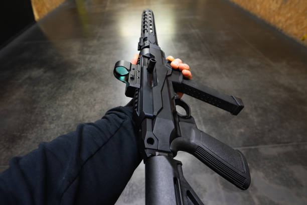 istock Tactical pcc rifle for 9mm pistol caliber with red dot sight in mans hand at shooting range. 2196537738