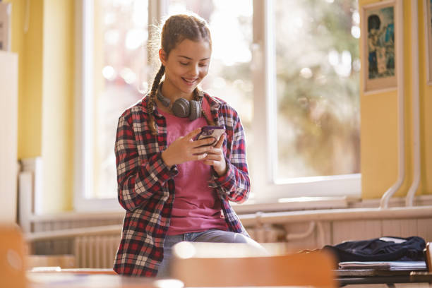 istock Girl whit headphones using mobile phone in the classroom 2196538724