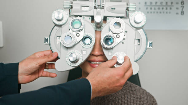 istock Optometrist Conducts Eye Test with Phoropter in Modern Office 2196539679