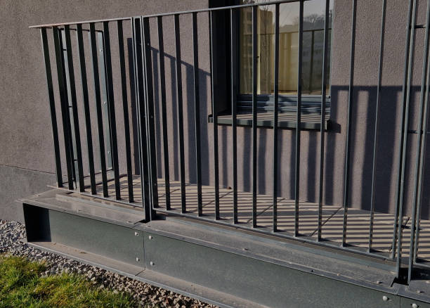 istock tower block railing with vertical fence posts anchored into the ground with four concrete screws. the railing is fixed from the side of the bridge into the concrete. 2196539764