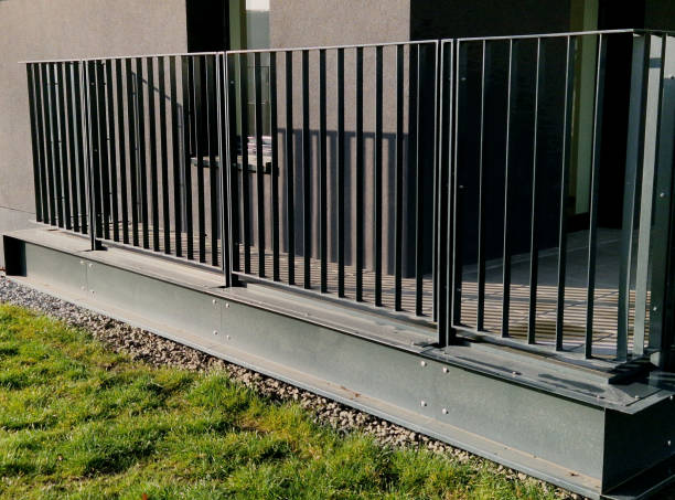 istock tower block railing with vertical fence posts anchored into the ground with four concrete screws. the railing is fixed from the side of the bridge into the concrete. 2196539769