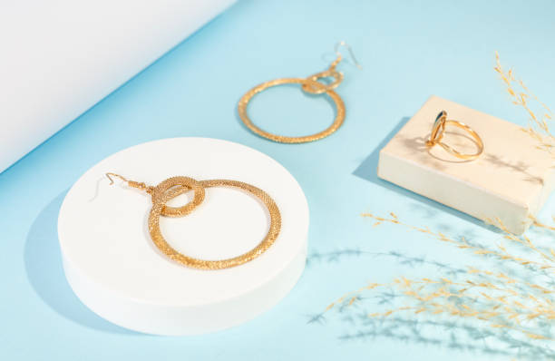 istock Golden earrings with decor on color background 2196539780