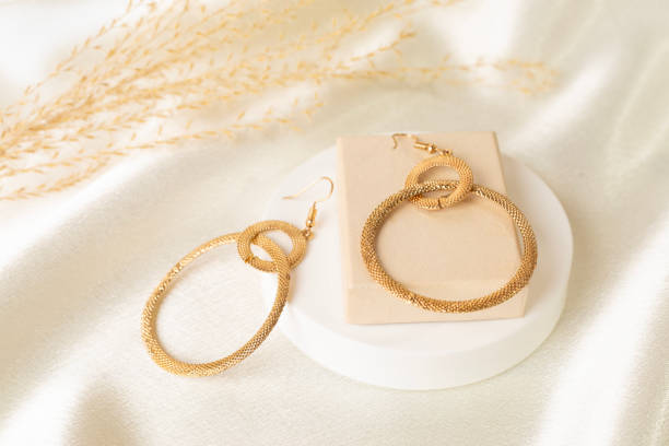 istock Golden earrings with decor on textile background 2196539782