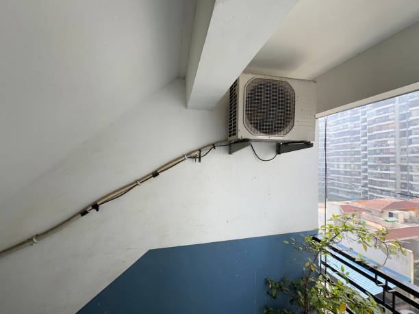 istock Image of unrecognisable Indian handyman installing an air conditioning extractor unit on apartment balcony 2196540247