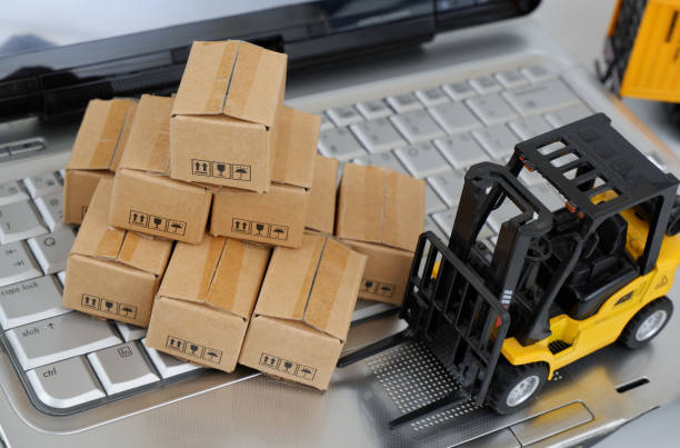 istock Top view of many carton boxes and forklift truck on computer keyboard. 2196540374